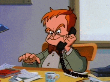 Captain Klegghorn at his desk, on the phone, drumming the fingers of one hand on the desk